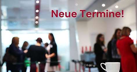 Eine Kaffeetasse steht auf einem Tisch, im Hintergrund sind Menschen.